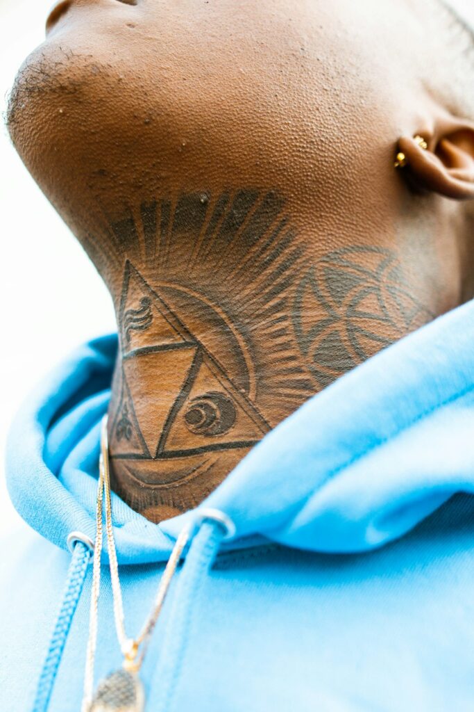 All seeing eye pyramid tattoo on a man's throat