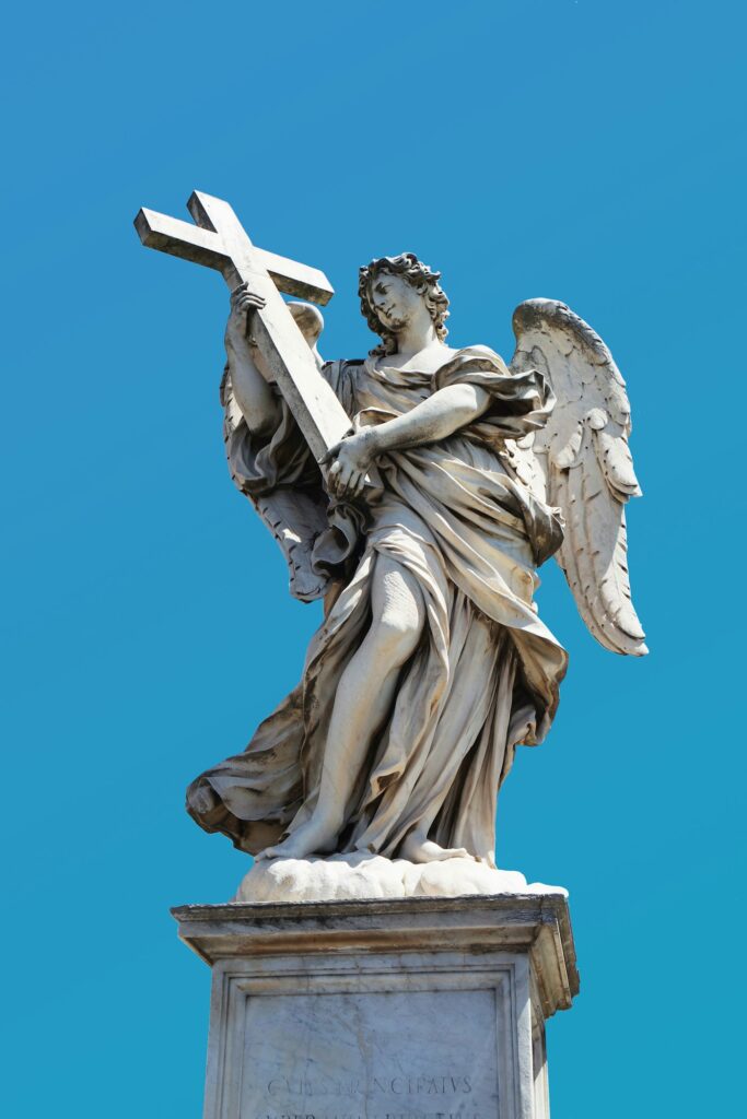 Stone angel statue carrying a cross