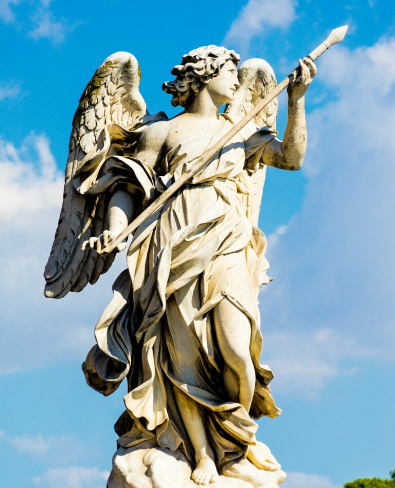 Angel tattoos for men: statue of an angel holding a spear against the sky
