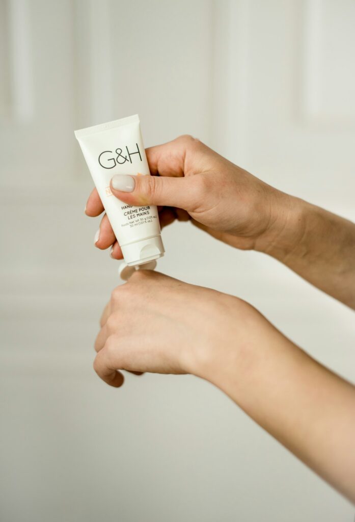 Squeezing a fragrance free moisturizing cream onto the hand