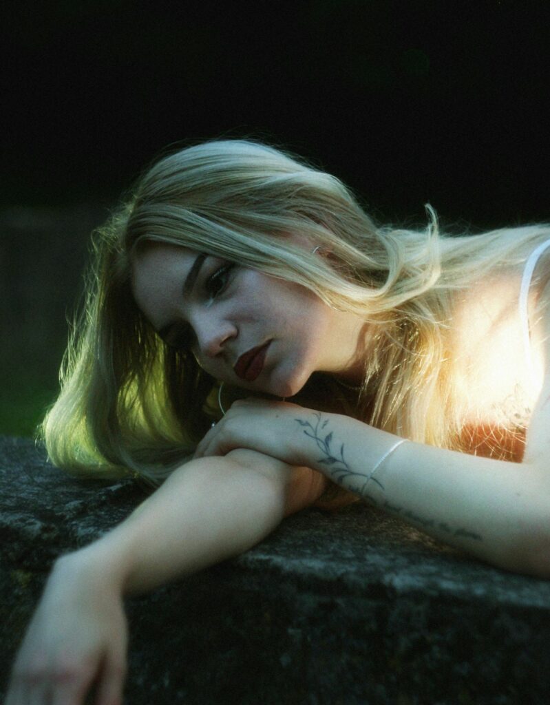 Blonde woman resting her tattooed arm