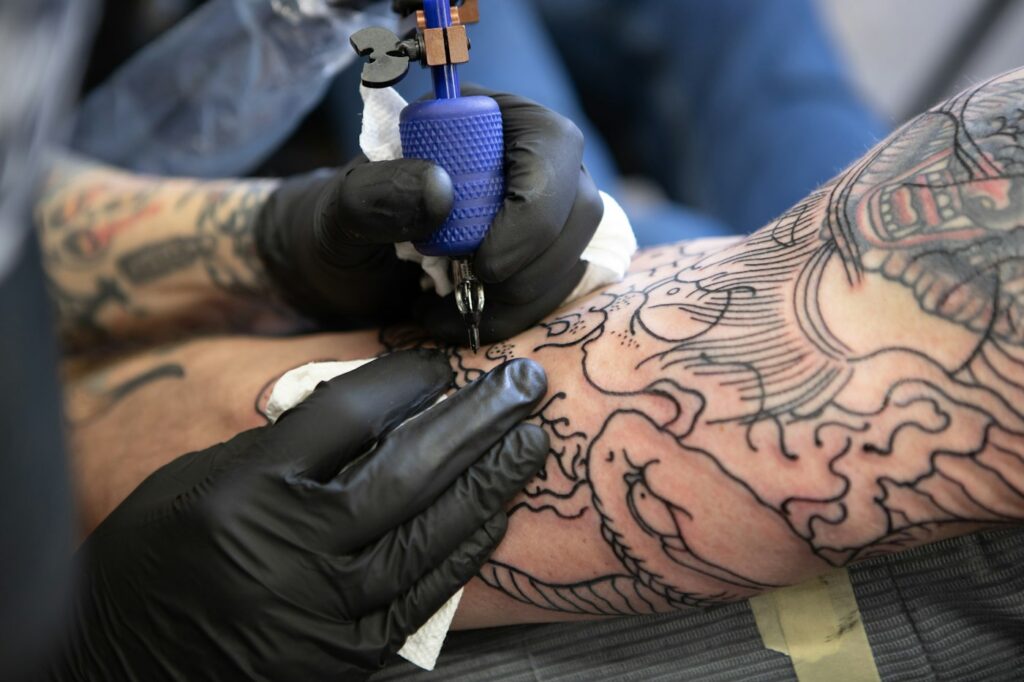 Tattoo artist tattooing an arm