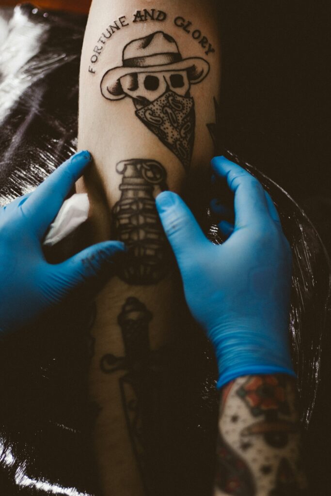 Tattoo artist working on a hand tattoo