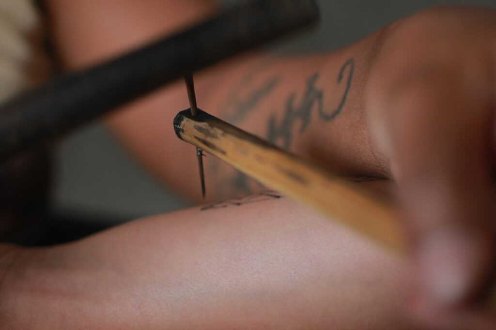 Traditional bamboo hand tapped tattoo on the arm