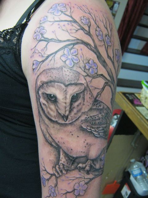 Barn owl and flowers tattoo on the upper arm