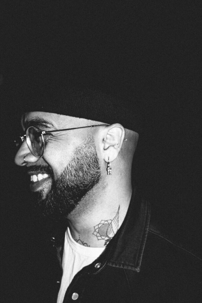 Smiling man with a tattoo behind the ear and on the neck