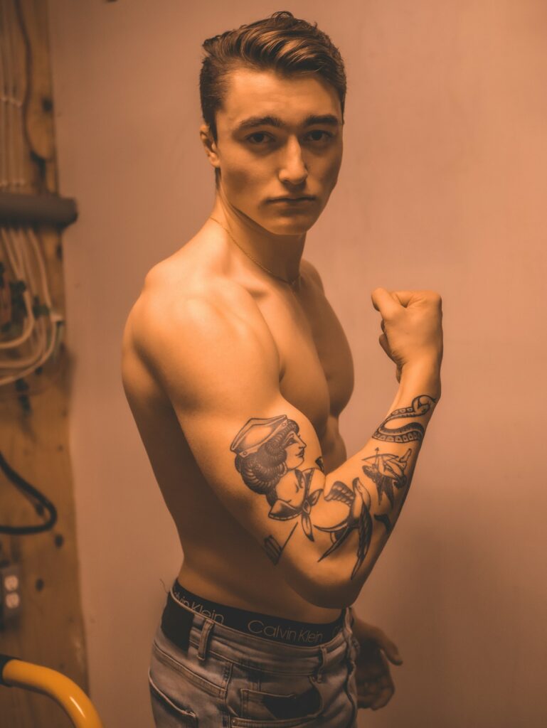 Black and grey bicep tattoo on a man flexing