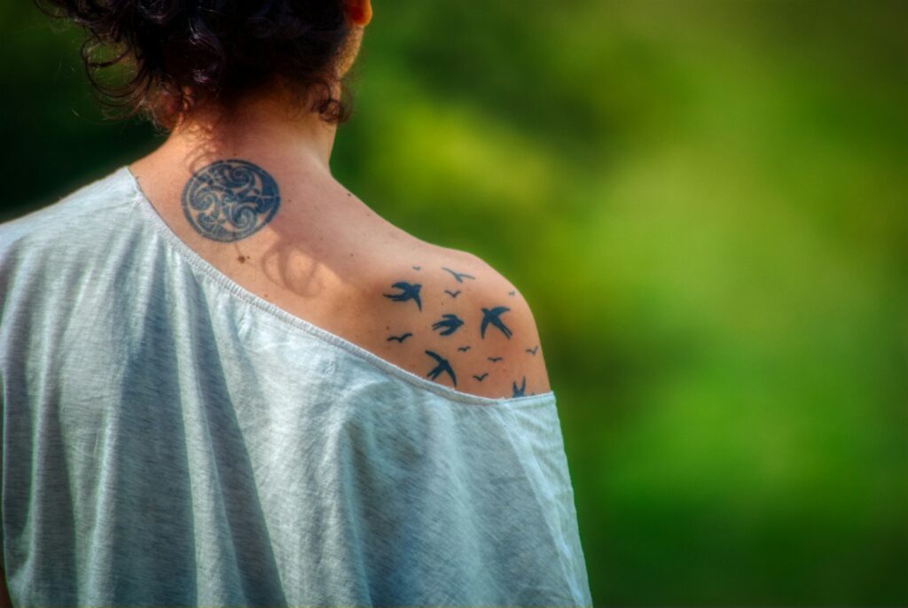 Flying birds tattoo on a woman's shoulder and upper arm