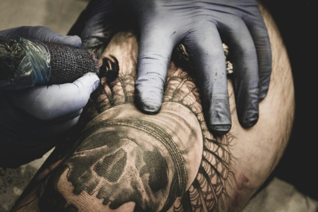 Black and grey skull sleeve being tattooed