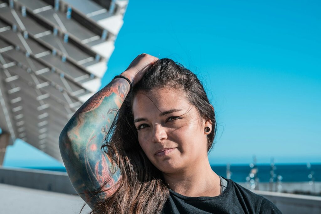 Woman in a black top with a full arm tattoo