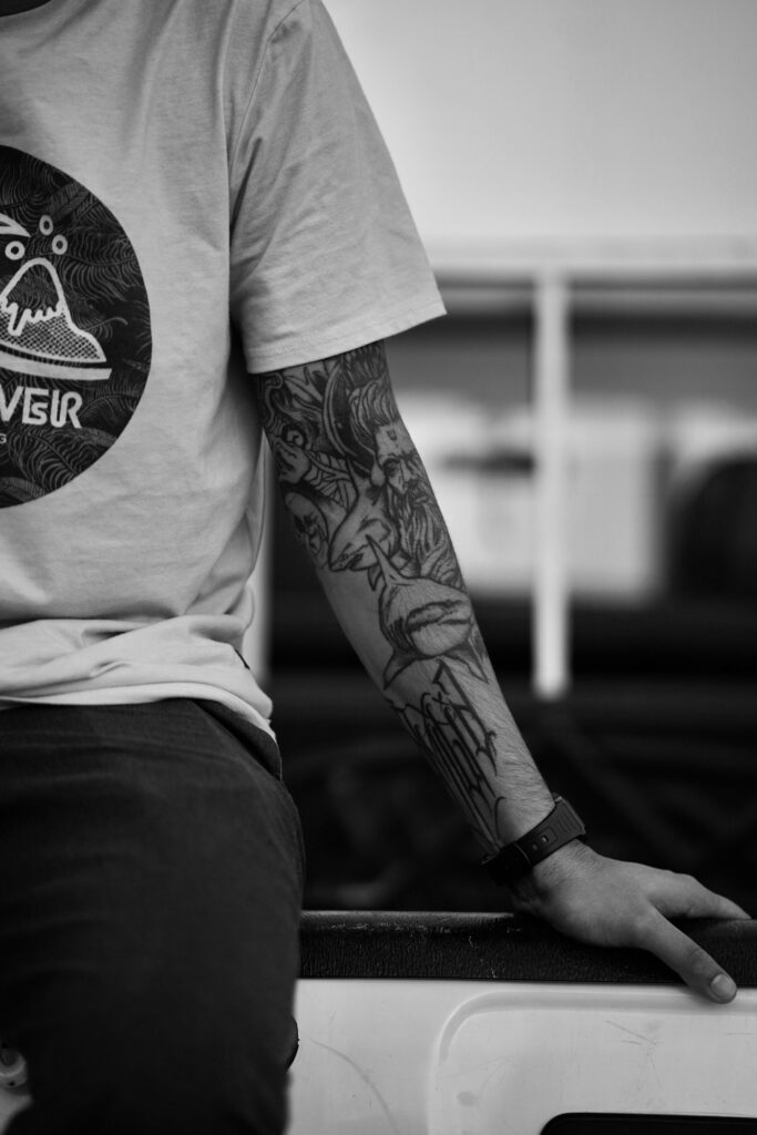 Black and grey lower sleeve on a man in a grey shirt