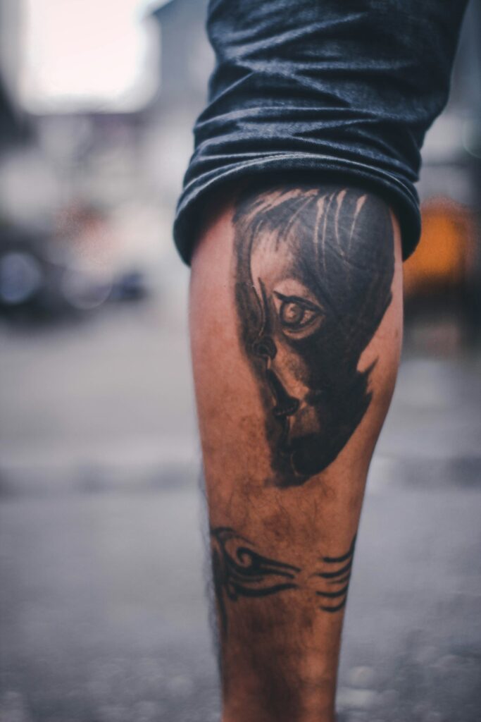 Black and grey portrait tattoo on a man's calf