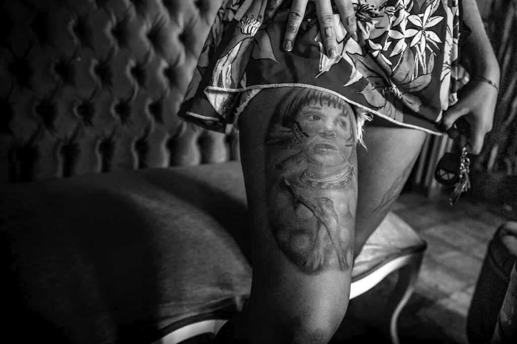 Black and grey portrait tattoo on a woman's thigh