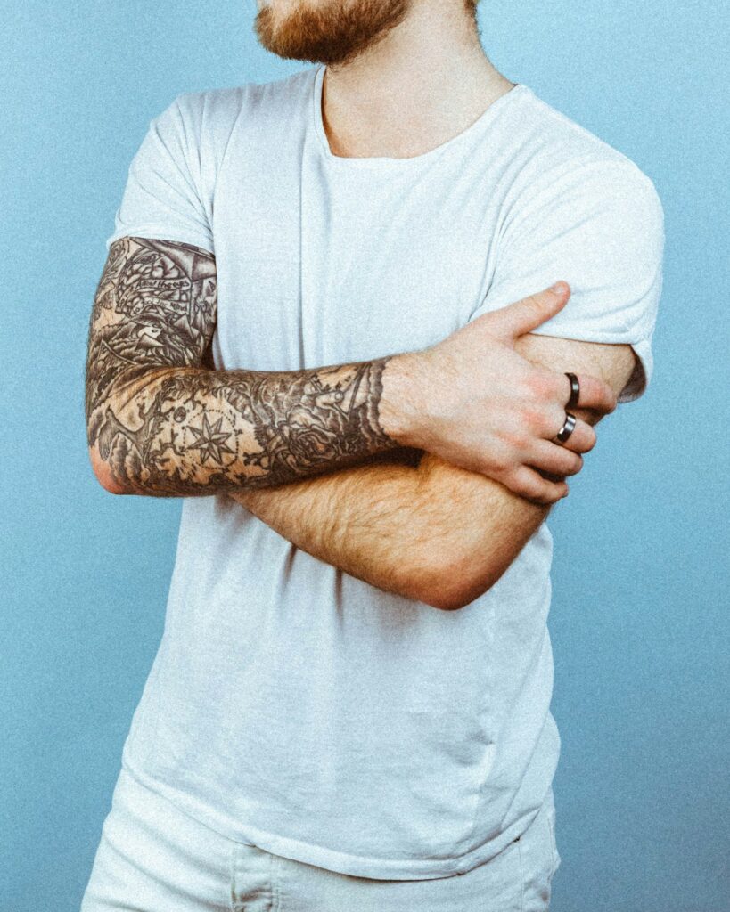 Black and grey sleeve tattoo on crossed arms