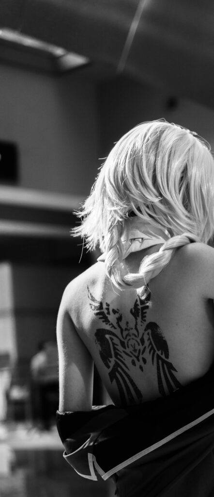 Black ornamental tattoo on a woman's upper back