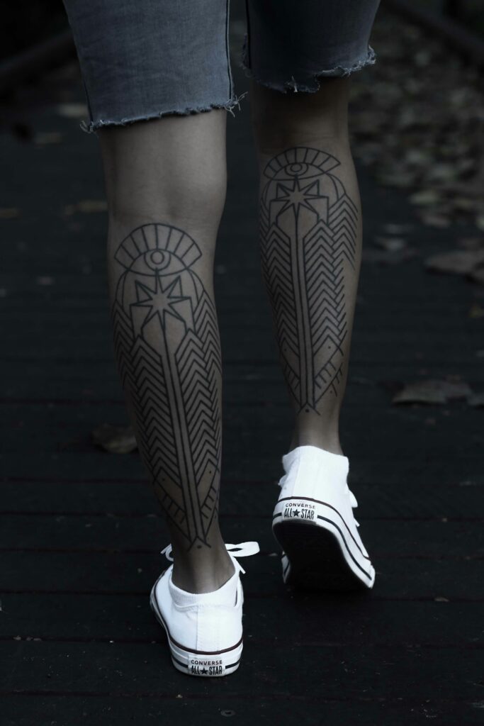 Geometric blackwork tattoos on both calves