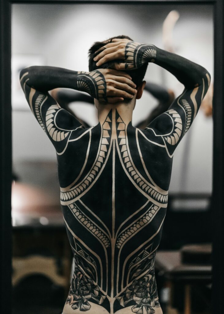 Bold blackwork tattoo style on the torso and arms