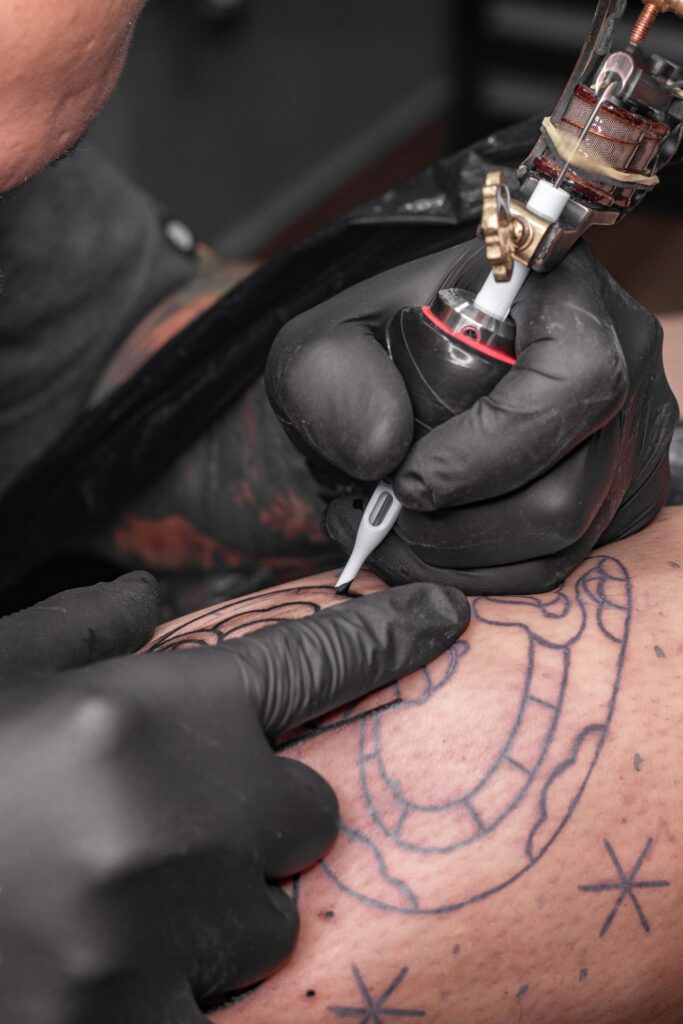 Bold black linework tattoo being inked