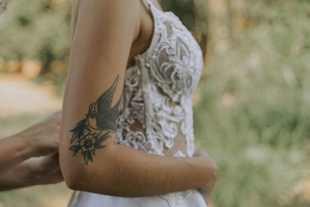 Bride with a floral and bird half sleeve tattoo