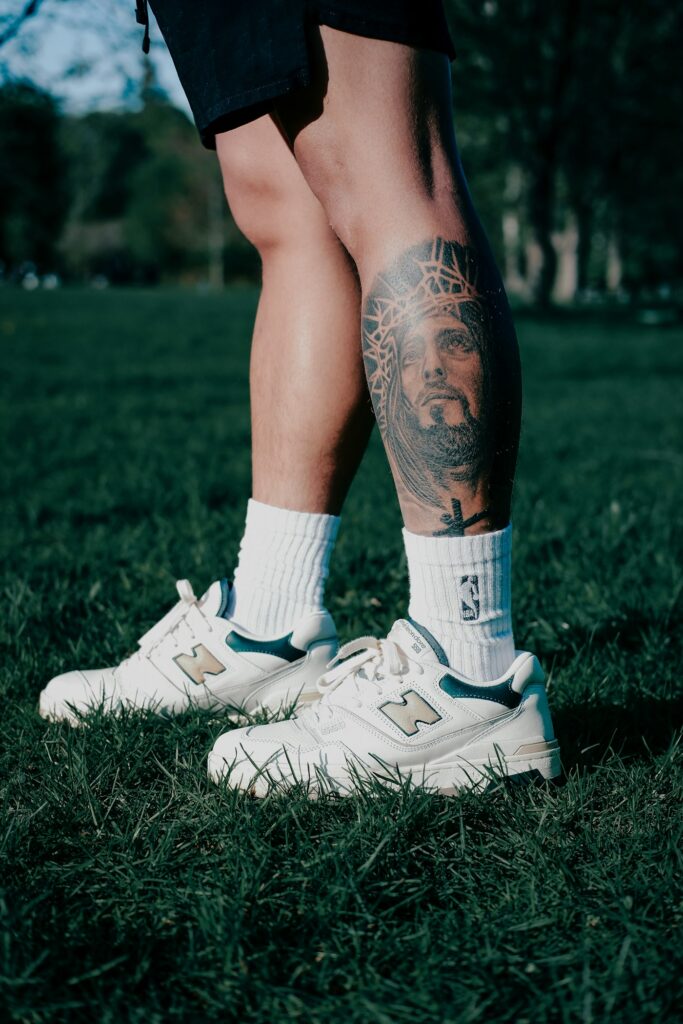 Black and grey calf tattoo above white sneakers