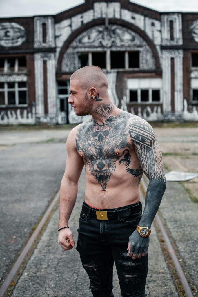 Chest and arm tattoos on a bald man outdoors