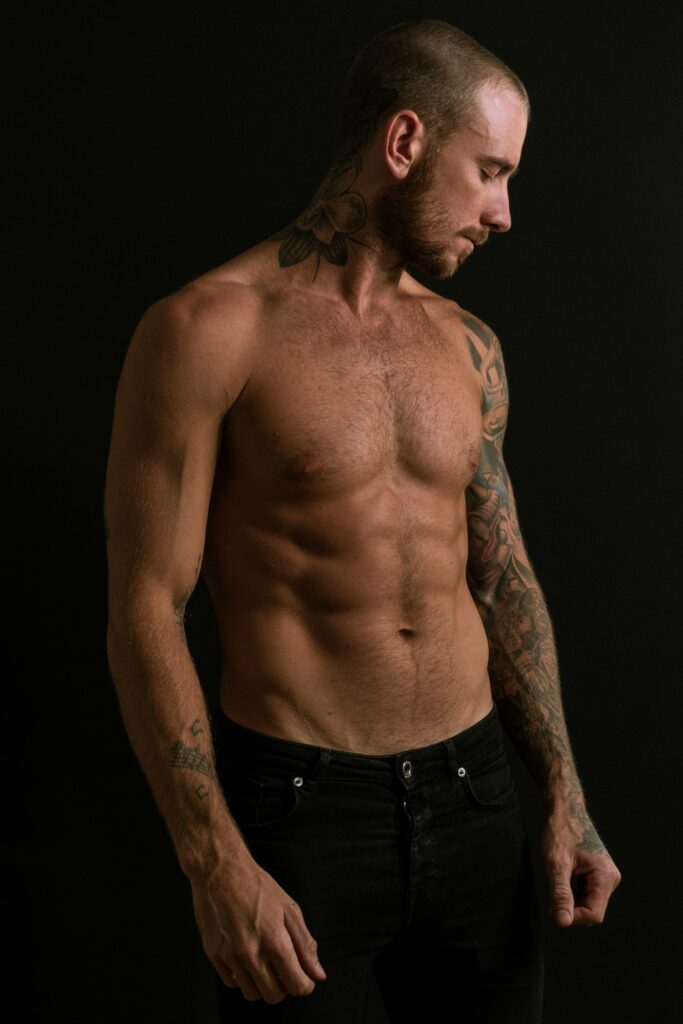 Chest tattoos for men: shirtless tattooed man against a dark background
