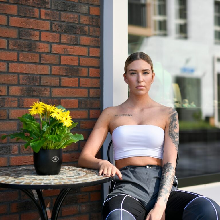 Chest tattoos for women: woman holding sunflowers with a chest tattoo