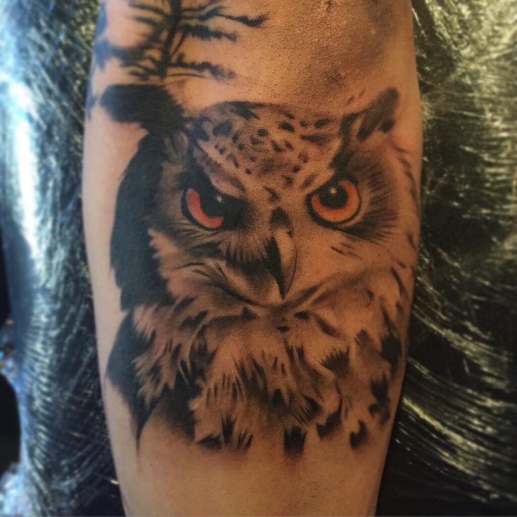 Realistic Owl With Orange Eyes on the Forearm