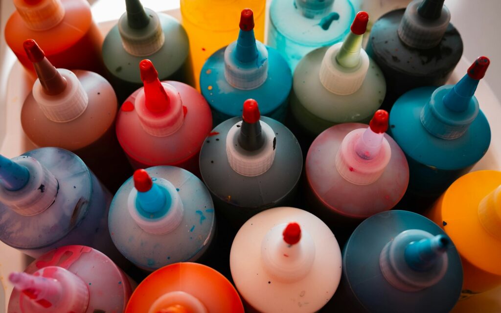 Colorful pigment squeeze bottles seen from above