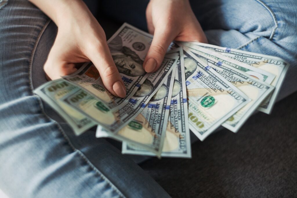 Hands counting a stack of US dollar bills