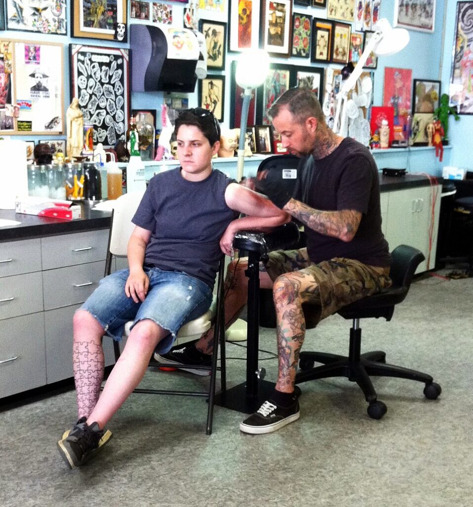 Cover up tattoo ideas: tattoo artist working on a cover up session in the studio
