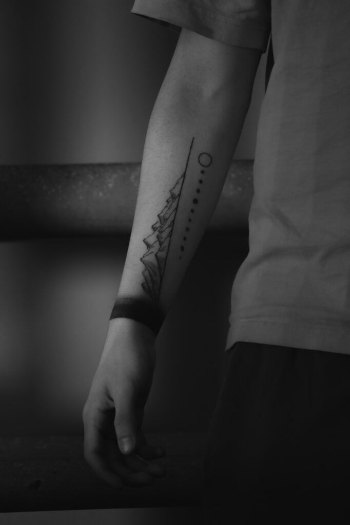 Black tattoo running from the wrist up the forearm
