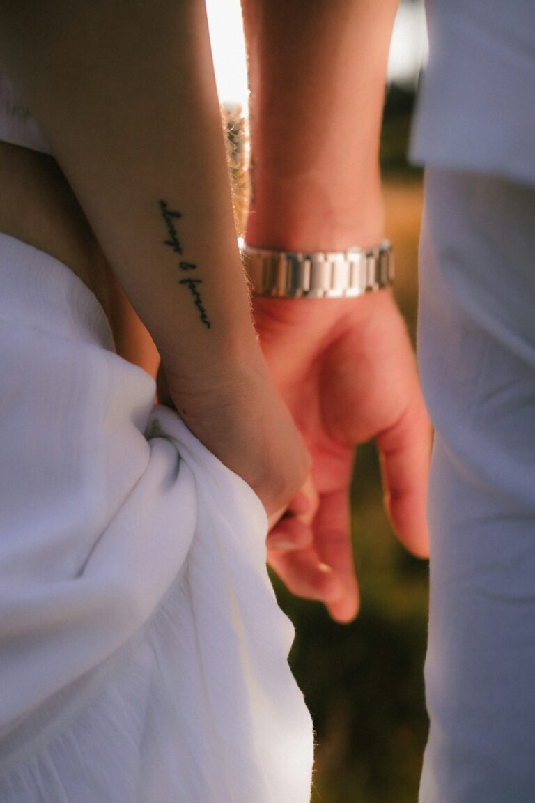 Family tattoo ideas: two people holding hands, one with a tattooed arm