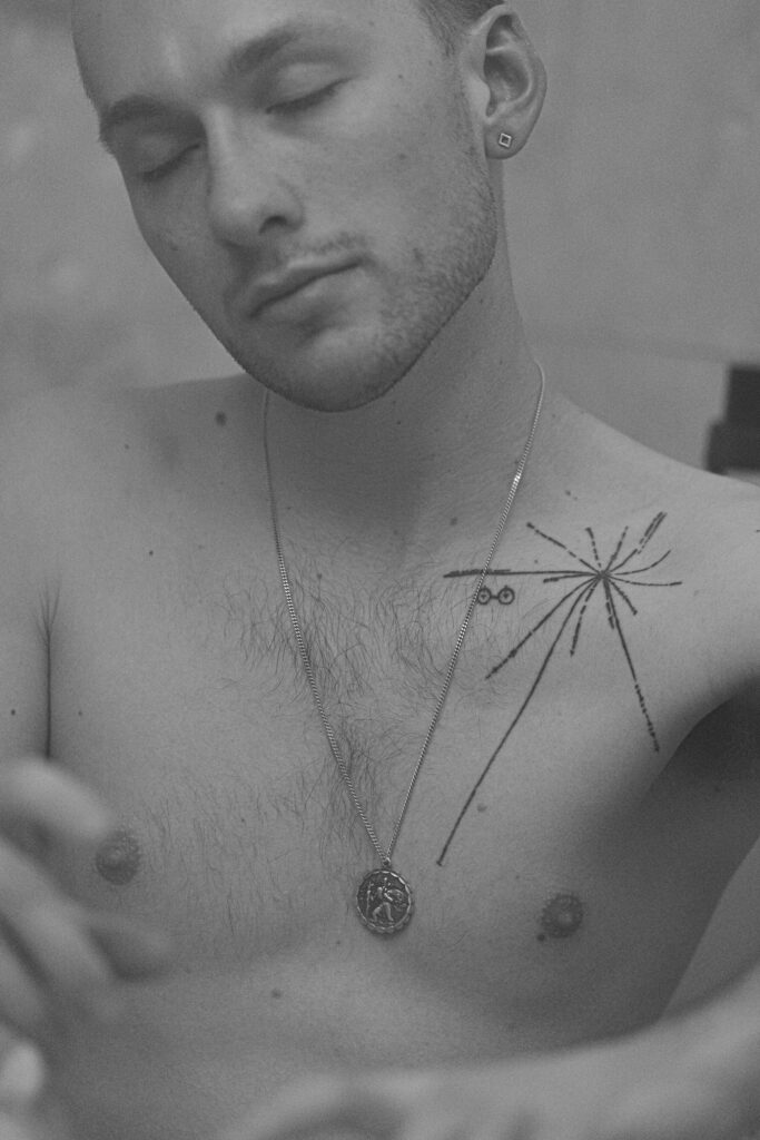 Fine line tattoo across a man's chest