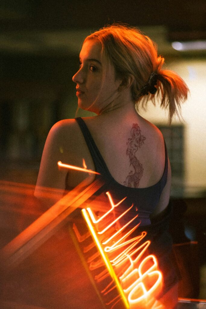 Fine line dragon tattoo on a woman's upper back