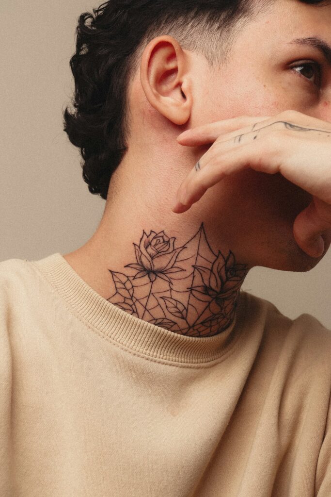 Fine line flower tattoo on a man's neck