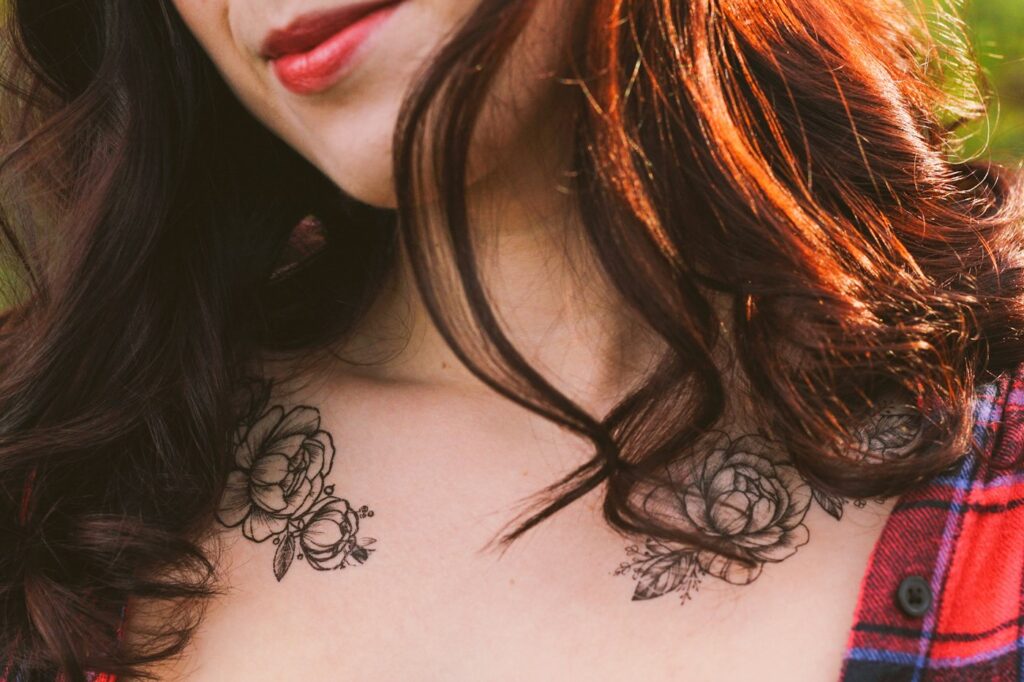 Fine line peony tattoos on both collarbones