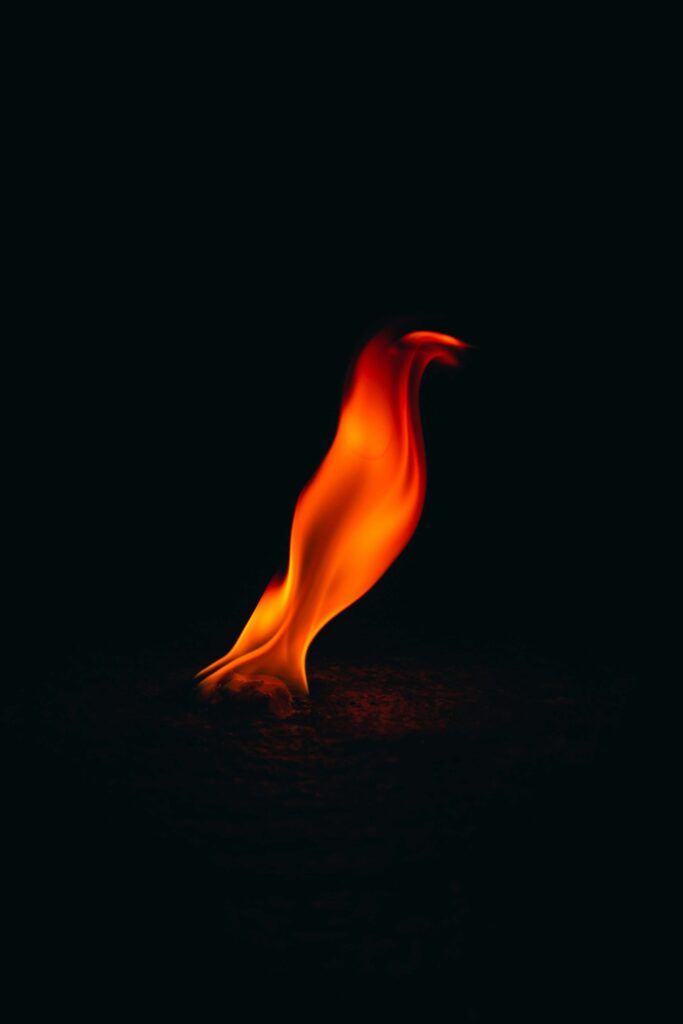 Bright flame on a dark background, symbol of rebirth