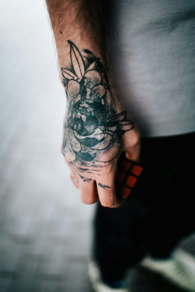 Floral hand tattoo with bold shading