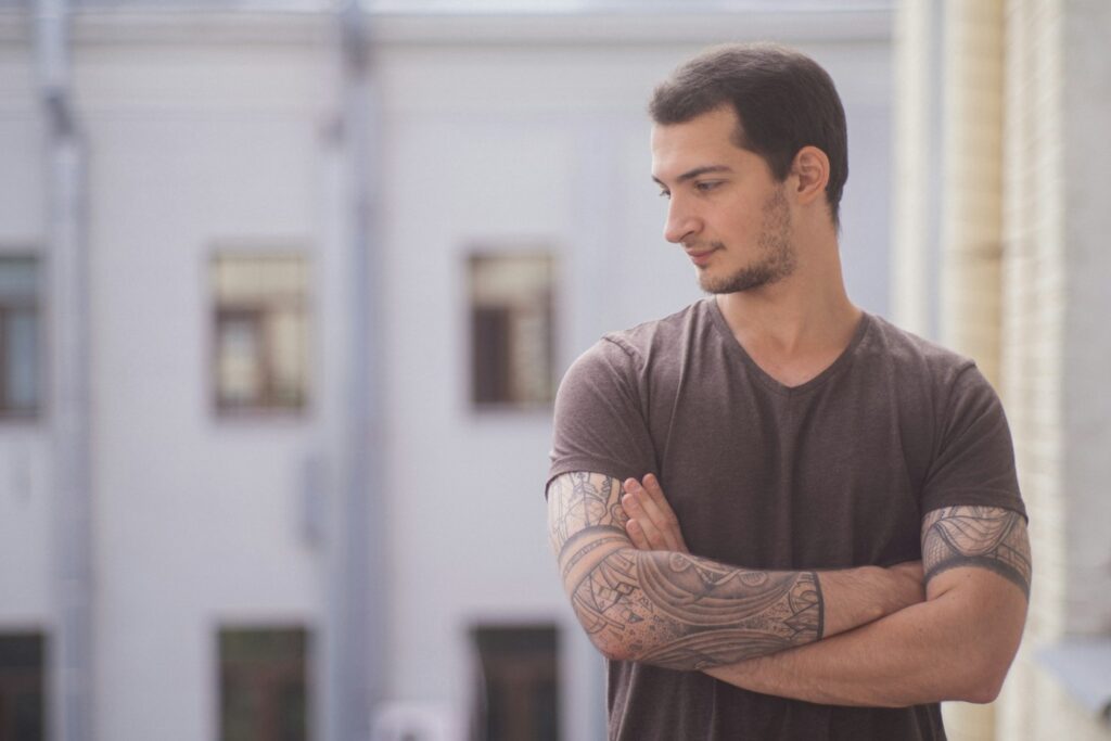 Black and grey forearm half sleeve on a man in a grey T-shirt