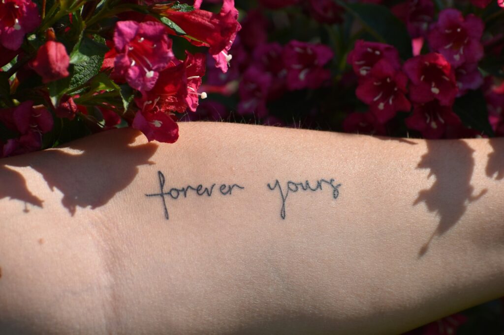 Forever yours handwritten script tattoo on the arm