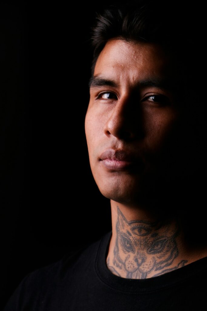 Black and grey front neck tattoo on a man
