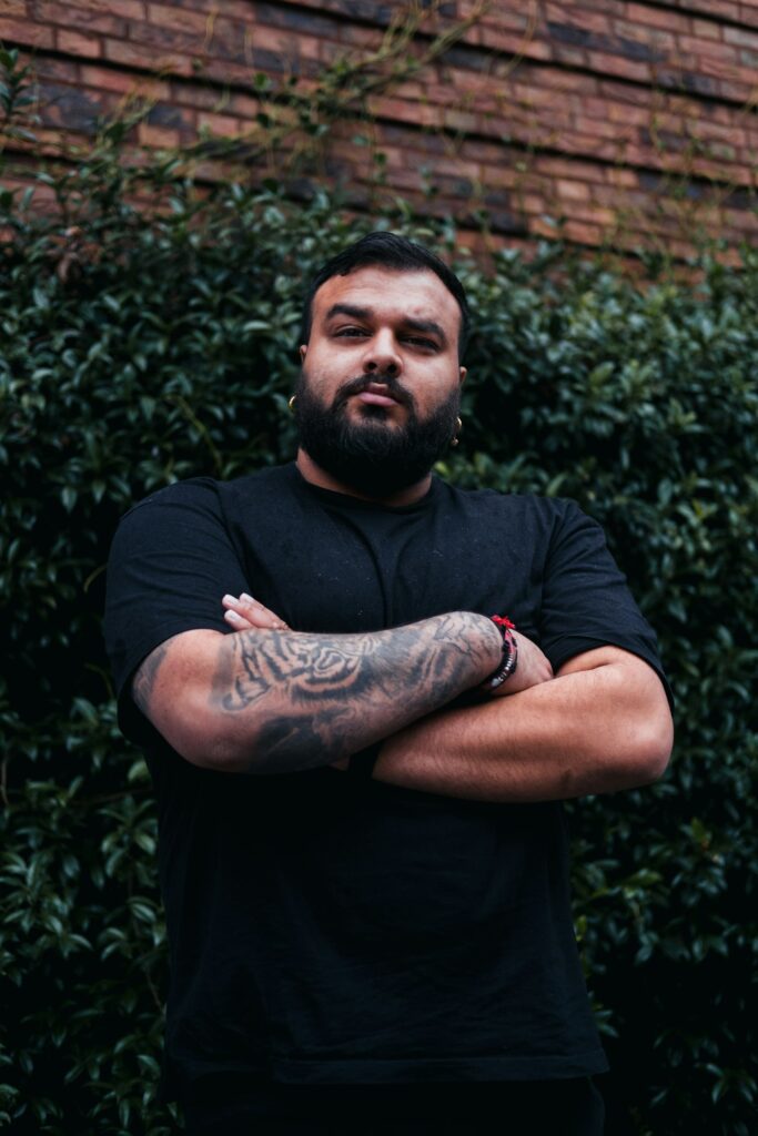 Man with full sleeve tattoos on both arms crossed