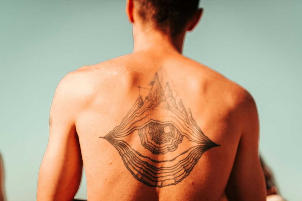 Geometric black tattoo across a man's upper back