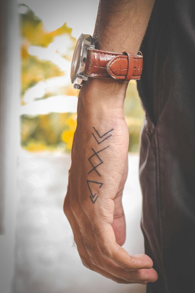 Small geometric line tattoo on a man's forearm