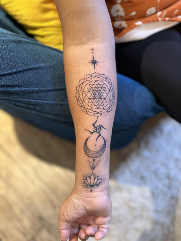 Geometric lotus tattoo on the inner forearm