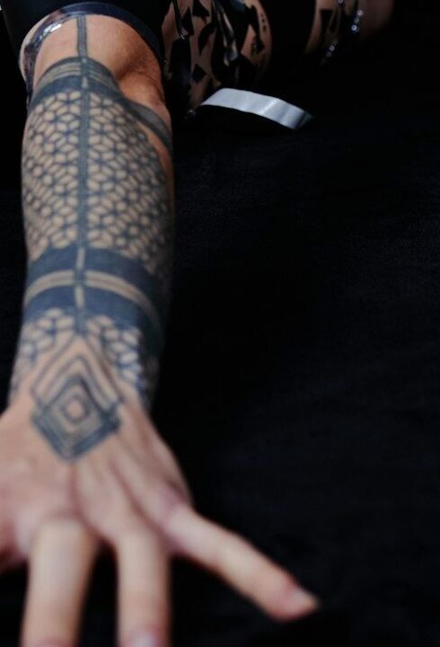 Half sleeve tattoos for women: geometric blackwork half sleeve on the forearm
