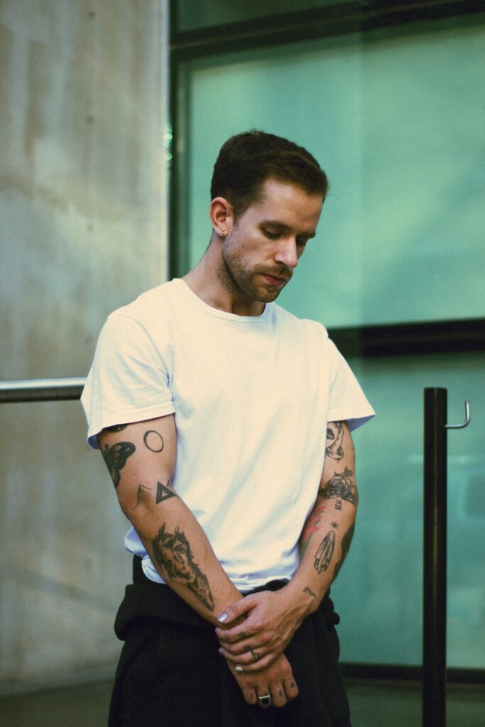 Man in a white T-shirt with half sleeves on both arms