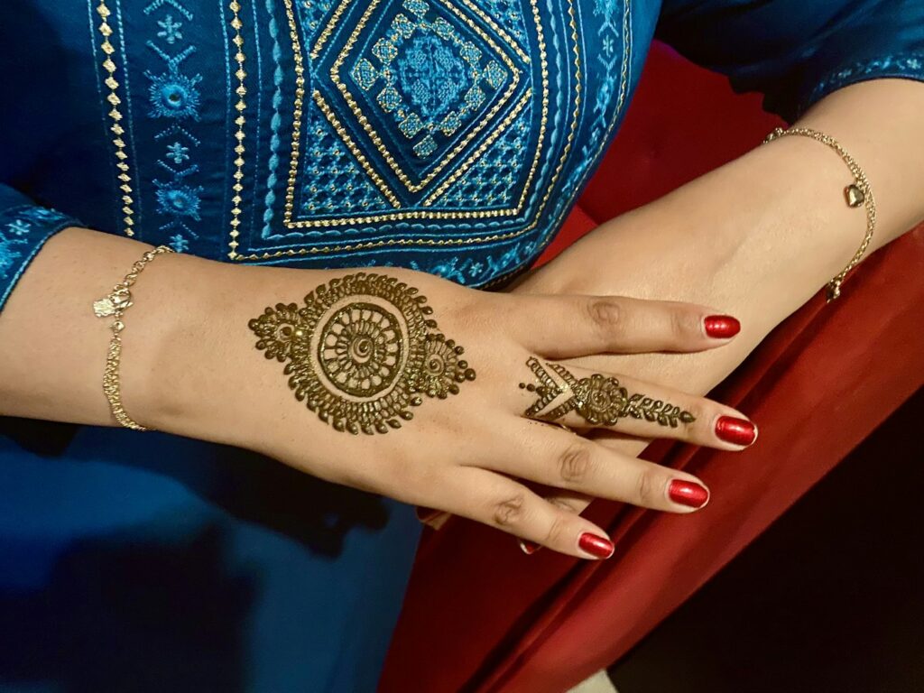 Henna medallion on the back of the hand with finger bands