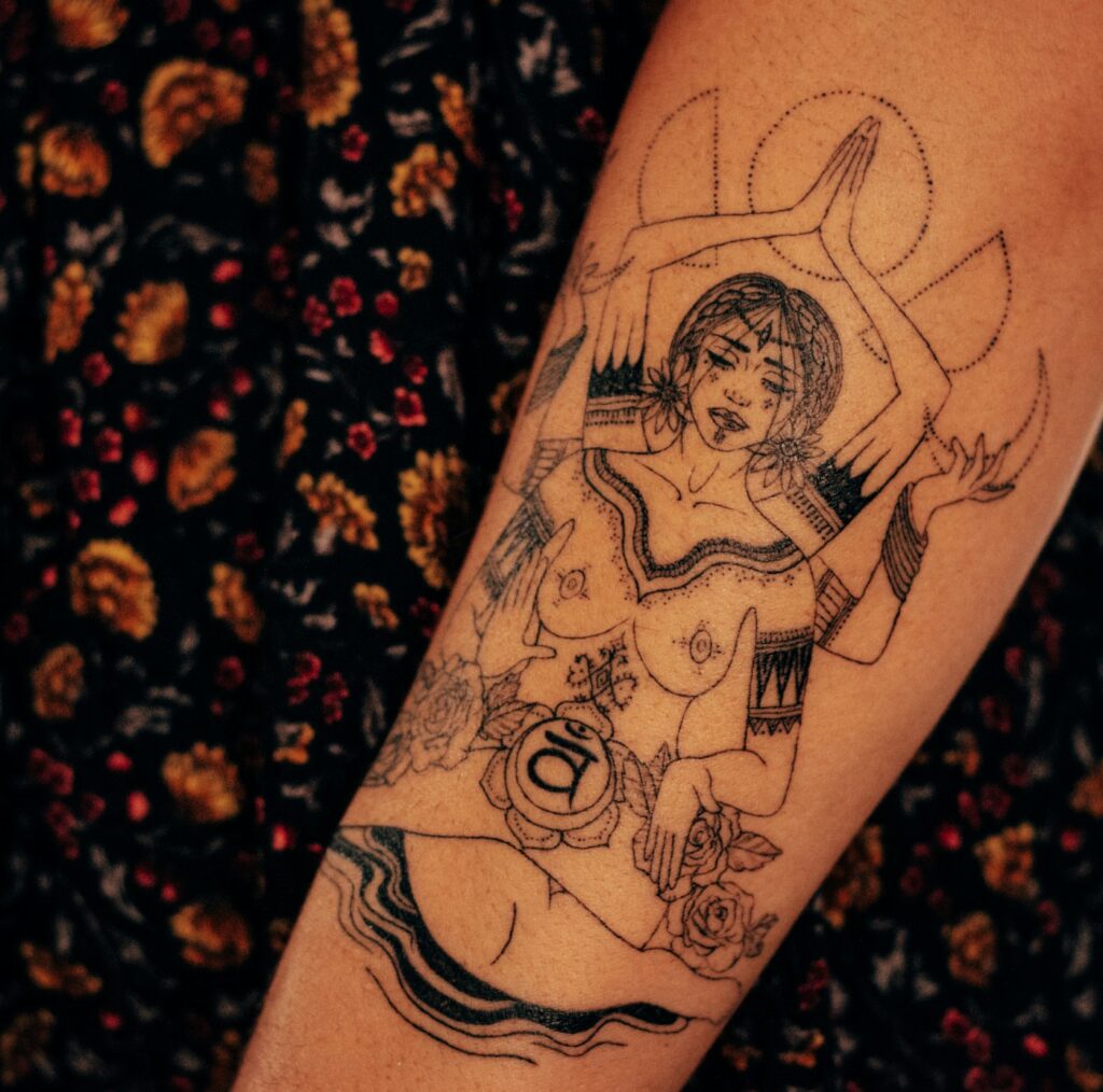 Illustrative female figure tattoo on the forearm